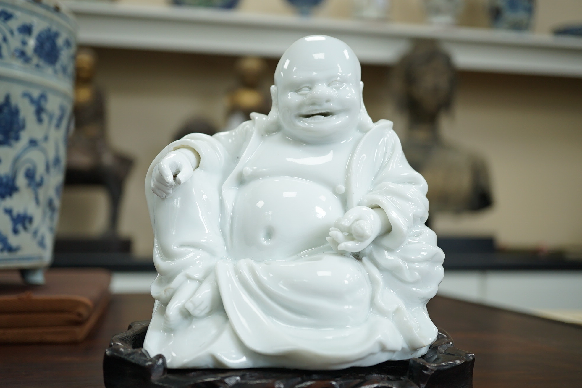 A Chinese blanc-de-chine seated figure of Budai, 18th/19th century
